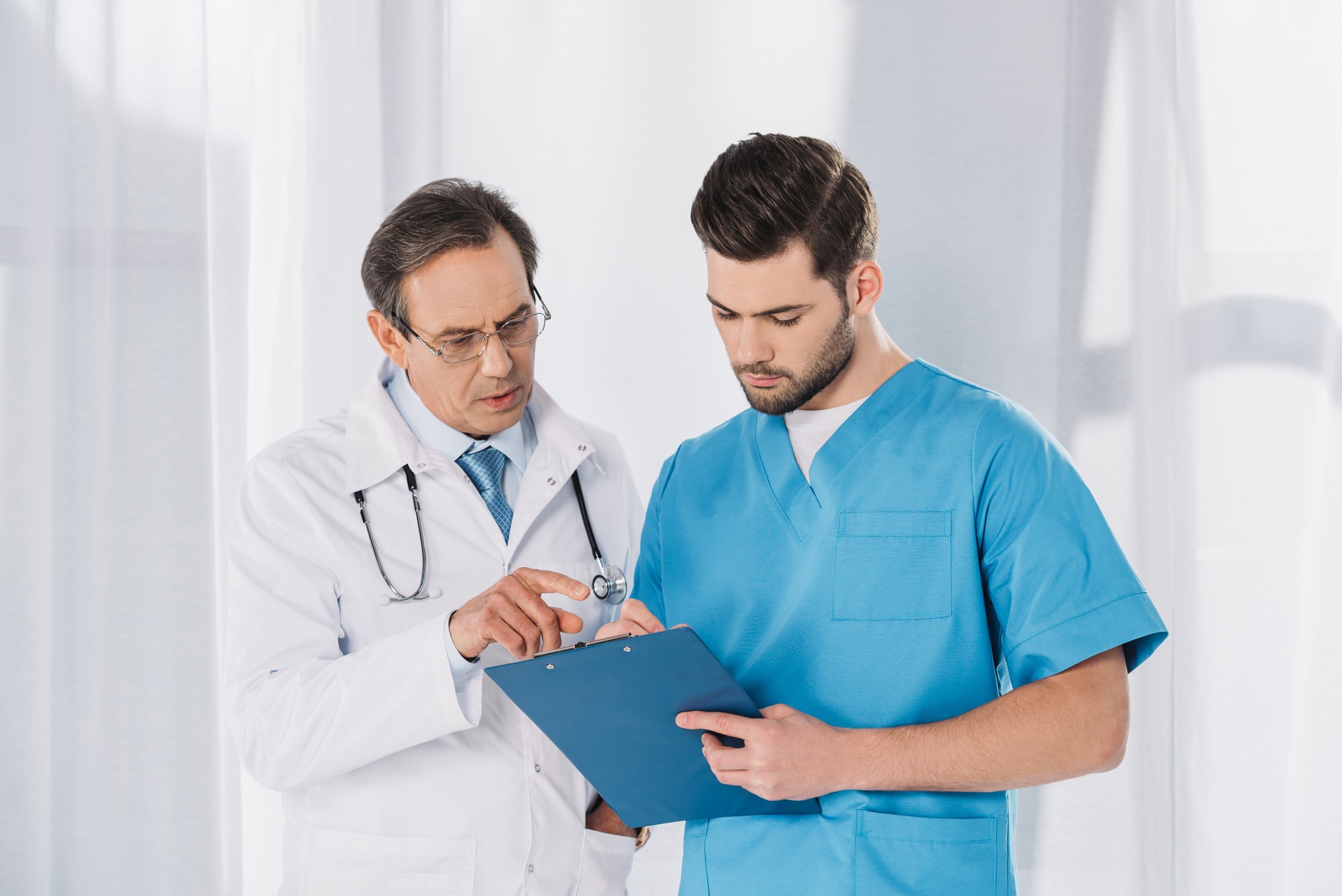 male-doctor-and-nurse-looking-at-clipboard.jpg